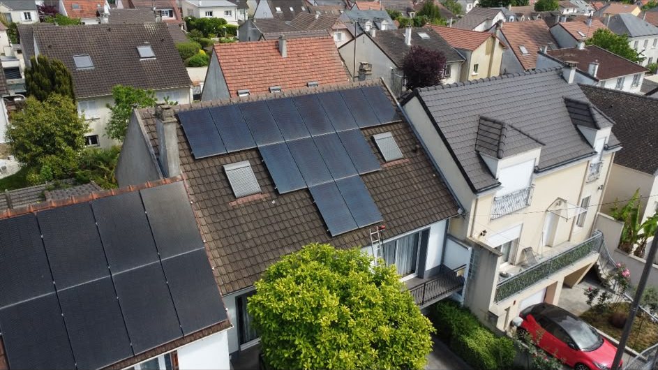 Vue aérienne de deux maisons voisines équipées de panneaux solaires photovoltaïques sur toiture en tuiles