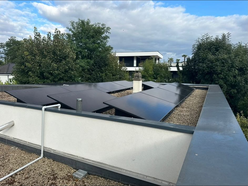 Panneaux solaires photovoltaïques installés sur le toit-terrasse d'une maison contemporaine